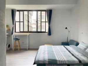 花莲市LeeHo B&B 李何寓所的一间卧室配有一张床、一张书桌和一个窗户。