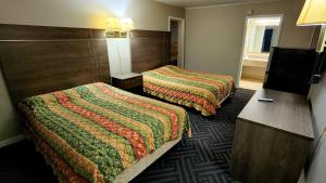 爱丽丝Alice Motor Inn的酒店客房设有两张床和电视。