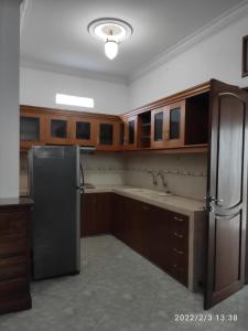 三宝垄Kelana 1 Luxury Homestay Semarang, 3 bedrooms的厨房配有木制橱柜和不锈钢冰箱。
