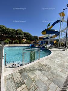 卡达斯诺瓦斯DiRoma Fiori Caldas Novas - YMT - 323的主题公园内一个带水滑梯的游泳池