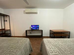 巴耶斯城CASA ROMEL的客房设有两张床、一台电视和一张桌子。