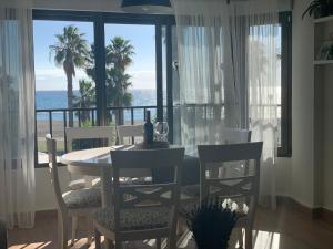 卡莱塔德贝莱斯Apartamento Puerto Blanco的一间带桌椅的海景用餐室