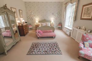 德比Breedon Hall的一间卧室配有一张床、两把椅子和镜子