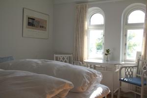斯文堡Troense Bed and Breakfast by the sea的一间白色卧室,配有床和2个窗户