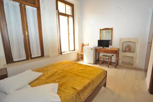 罗希姆诺拜占庭酒店的一间卧室配有一张床、一台电视和一张书桌