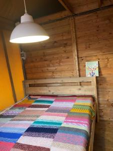 卢特伦Safari lodge tent op prachtige plek的小木屋内的一张床位,配有色彩缤纷的被子