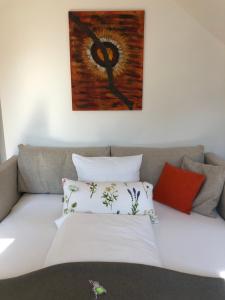 埃伦豪森Villa zur Schmied'n的一张带枕头的沙发以及墙上的绘画作品