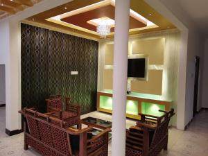 贾夫纳纳鲁尔假日旅馆的大堂设有椅子和客房内的电视