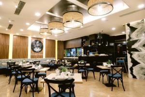 宿务Goldberry Suites and Hotel Cebu的一间带桌椅的餐厅和一间酒吧