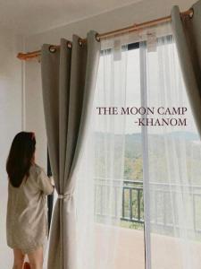 Ban PlauThe moon camp khanom的一个年轻女孩从窗口望出去