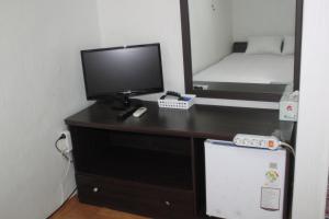 首尔东大门旅馆的一张桌子、一台电视和一张位于房间里的床