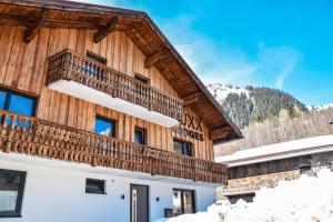 豪尔兹高LUXX Lodges - Holzgau - Lechtal - Arlberg的一座带阳台的雪地建筑