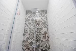 扎达尔Dandelion hostel的带淋浴的浴室(带瓷砖墙)