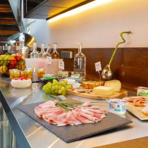 米卢斯Berti Hotel - Mulhouse Centre Gare的上面有肉、奶酪和其他食物的柜台