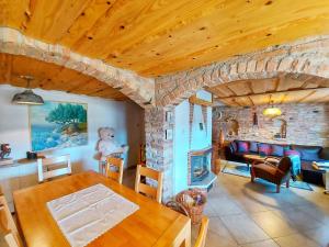 科雷尼察Peter's Pine Cottage的客厅配有桌子和石头壁炉