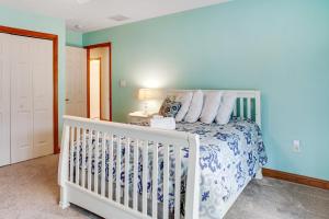 Long PondMountain Oasis的卧室里设有一张白色的婴儿床,卧室里设有蓝色的墙壁