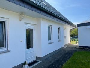 默讷塞Ferienwohnung Derk的白色房子的一侧有一扇门