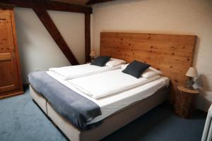 格吕耶尔格鲁耶尔客房酒店的一间卧室配有一张大床和木制床头板