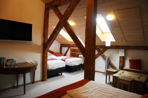 格吕耶尔格鲁耶尔客房酒店的客房设有两张床、一张桌子和一台电视机。