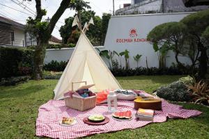 万隆Roemah Renjana Bandung的一张带食物和圆锥形帐篷的野餐桌