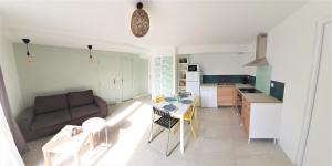 艾克斯莱班LA PIERRINA - Marmotte - Appart 3 étoiles的客厅以及带沙发和桌子的厨房。