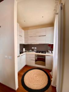 穆拉诺DUOMO Murano Apartment with Canal view的厨房配有白色橱柜和地板上的地毯