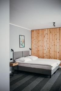斯蒂格纳Bursztynowy Sen Stegna的一间卧室设有一张大床和木墙