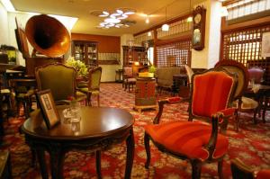 武雄市京都亚酒店的一间摆放着椅子和桌子的房间,一间