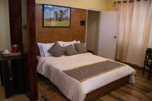 西隆The Arcadia Resort - Umroi的卧室配有一张床,墙上挂着一幅画