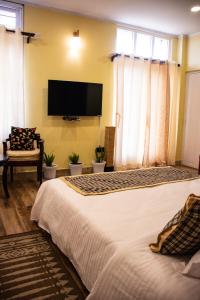 西隆The Arcadia Resort - Umroi的一间卧室配有一张大床和一台平面电视
