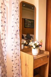 西隆The Arcadia Resort - Umroi的梳妆台,上面装有镜子和鲜花