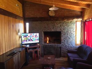 Los CipresesCabaña Fer的客厅设有壁炉和电视。
