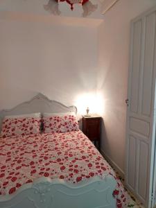 佩戈LA CASA DEL SOL的一间卧室配有一张带红色和白色棉被的床