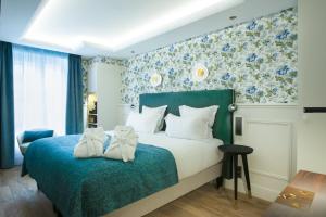 巴黎加蓬酒店的一间卧室配有一张蓝色花卉壁纸床
