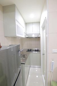 台南香草居二号房的小厨房配有白色橱柜和水槽