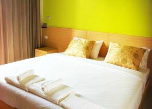 邦波BANGKOK.GRAND.RESORT的一间卧室配有一张白色的床和绿色的墙壁