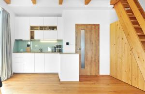 克维尔达Kvilda Apartments的厨房配有白色橱柜和木门。