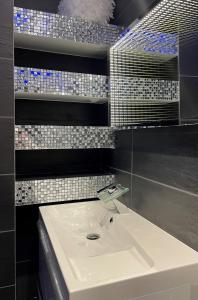 弗雷瑞斯La desiroom的浴室设有白色水槽,墙上铺有瓷砖。