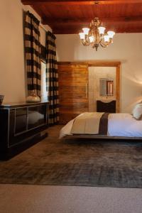 开普敦Bloemendal Wine Estate Accommodation的一间卧室配有一张大床和一个吊灯。