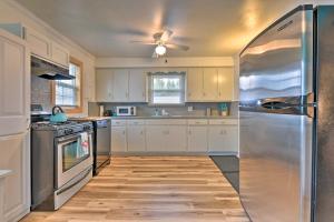 伊利Family-Friendly Hideaway Near Presque Isle!的厨房配有白色橱柜和不锈钢冰箱