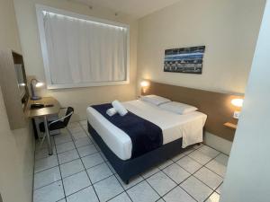 弗洛里亚诺波利斯Hotel de Carvalho的酒店客房设有一张床和一张小桌子。