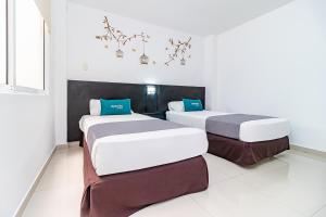 约帕尔Ayenda Quinta Estación的白色墙壁客房的两张床