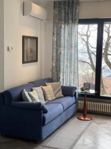 圣马力诺Casali appartamento的客厅设有蓝色沙发,配有窗户