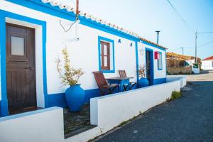 Farelos de BaixoParaíso dos Avós的蓝色和白色的房子,配有桌子和门