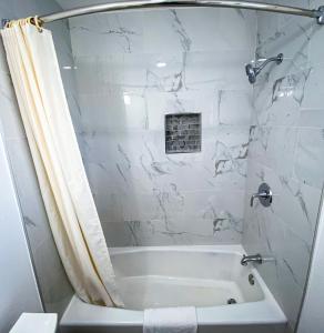 圣巴巴拉城市和乡村旅馆的白色的浴室设有浴缸和淋浴。