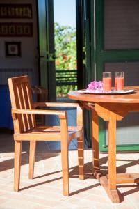 圣亚加塔·迪·米利特Rosmarino Park的一张木桌和一张椅子,坐在桌子旁