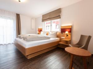 马克多夫Landgasthof Linde Hepbach, Hotel & Restaurant的卧室配有1张床、1张桌子和1把椅子