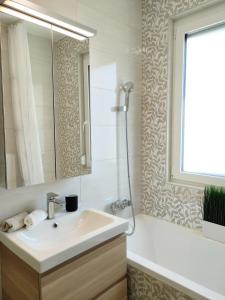 凯斯特海伊NEST2 Apartments的一间带水槽、浴缸和镜子的浴室