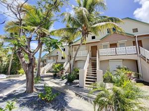 东方湾Maracuja 9, Orient Bay village, walkable beach at 100m的前面有棕榈树的房子