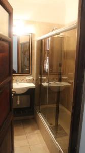 萨尔塔Tradición de Salta的一间带两个水槽和玻璃淋浴间的浴室